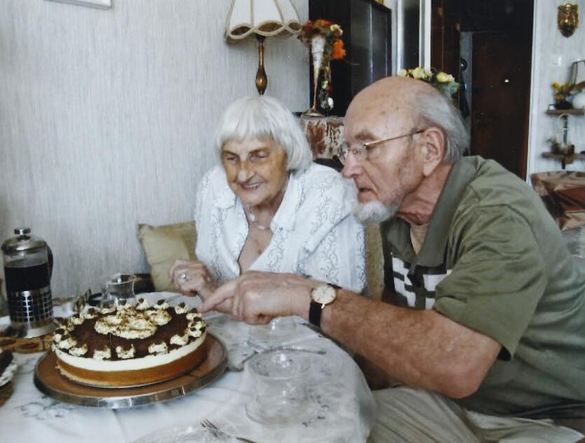dwoje starszych ludzi siedzi nad tortem z napisem 85 lat