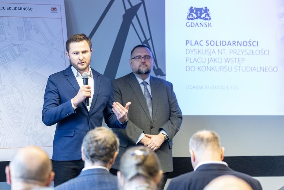Na zdjęciu zastępca prezydent Gdańska Piotr Grzelak, który mówi do mikrofonu i stojący obok niego Architekt Miasta Gdańska prof. Piotr Lorens 