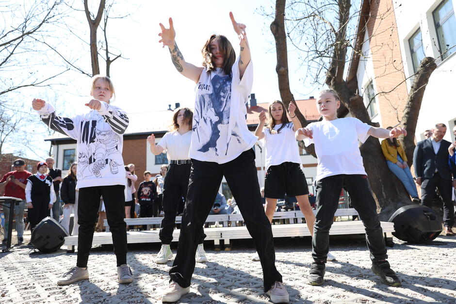 na zdjęciu kilka młodych dziewcząt tańczy, widać element choreografii, mają ubrane białe koszulki