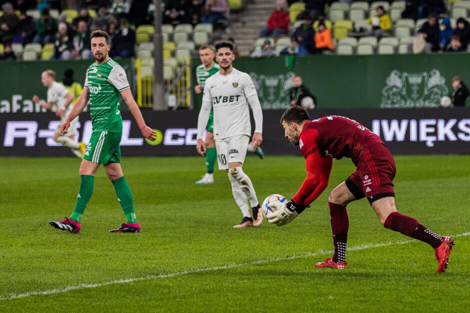 Trzech piłkarzy, w środku w białym stroju (Śląsk)