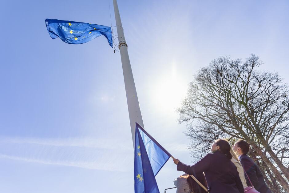 Wysoki maszt, na nim niebieska flaga Unii Europejskiej 