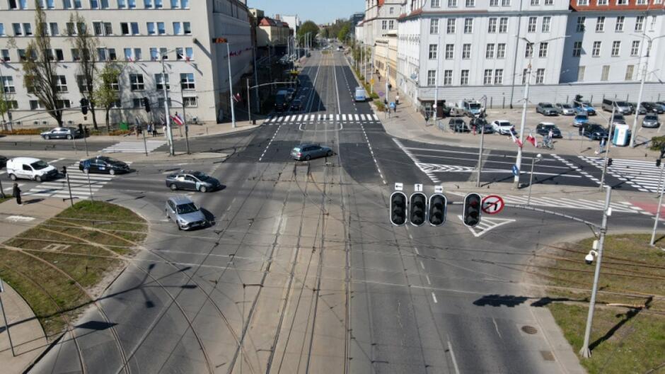 na zdjęciu z drona widać duże skrzyżowanie w centrum gdańska, którym jada samochody, w tle widać kilka budynków