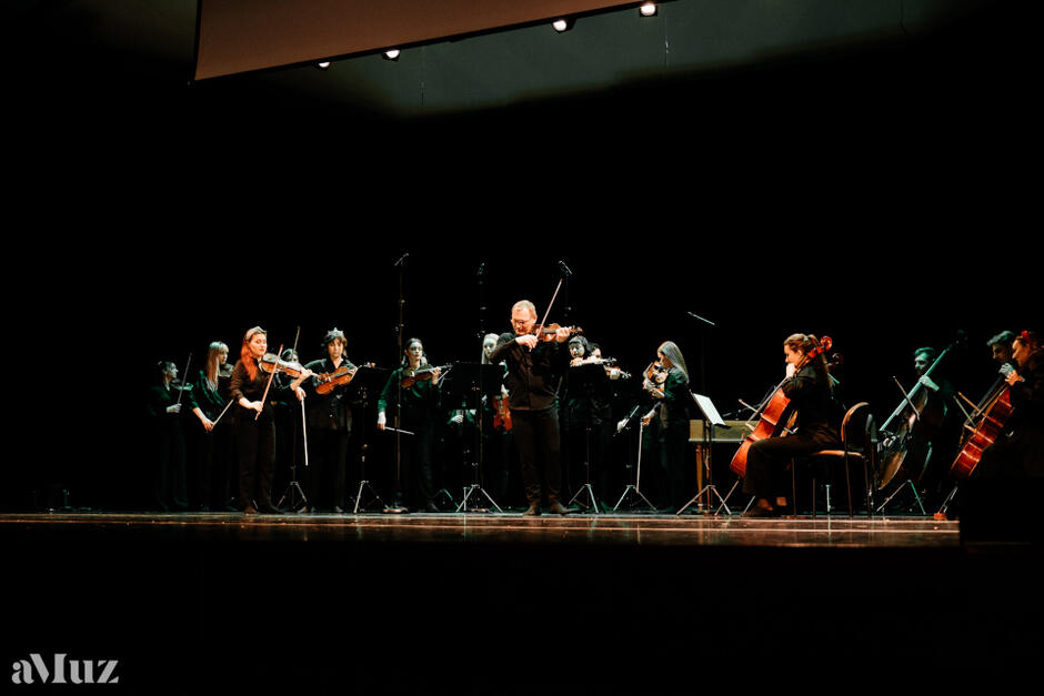 kilkunastu muzyków skrzypkowych na scenie podczas koncertu