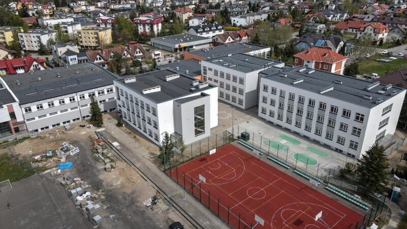na zdjęciu z drona widać jasny budynek szkolny składający się z kilku mniejszych budynków