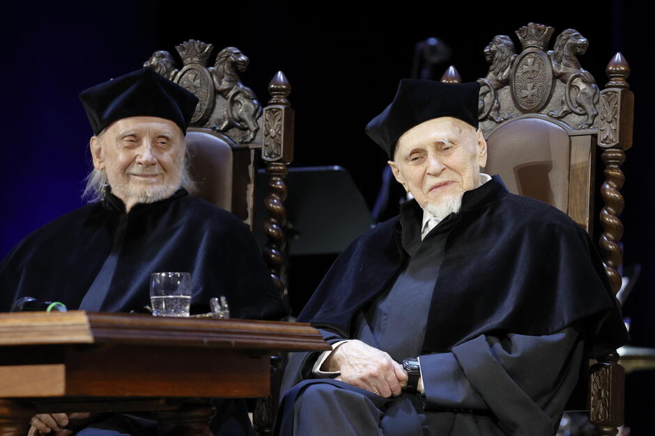 dwóch uśmiechniętych starszych mężczyzn w czarnych togach