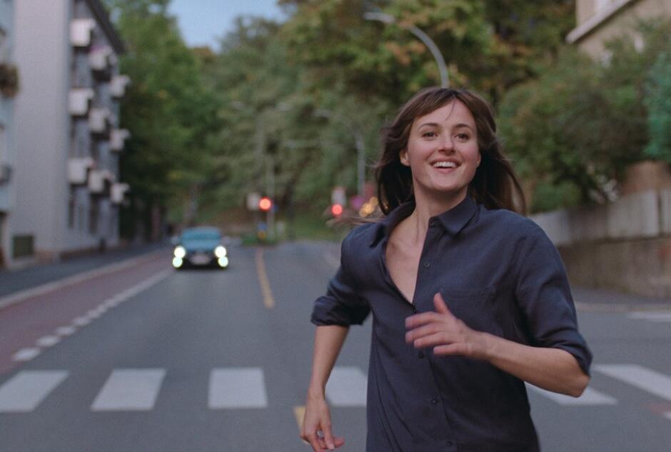 kadr z filmu - dziewczyna biegnąca ulicą 