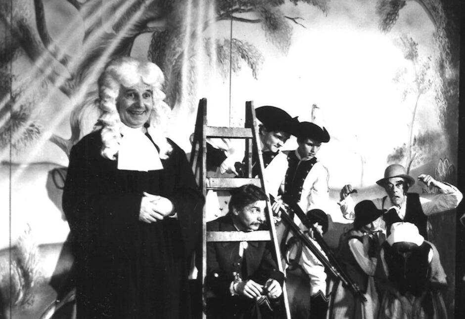 czarno-białe zdjęcie ze spektaklu, aktor w peruce sędziowskiej i todze