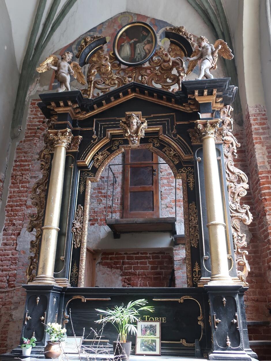 Zabytkowy ołtarz z drewnianymi rzeźbami sakralnymi