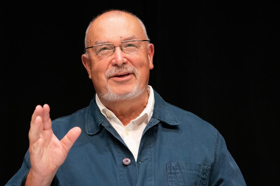 Twarz mężczyzny w średnim wieku z uniesioną dłonią