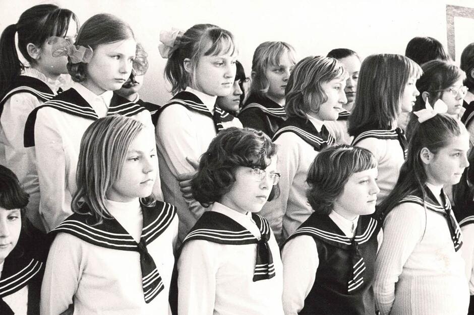 Czarno-białe zdjęcie. Dziewczynki w białych koszulach i marynarskich kołnierzach