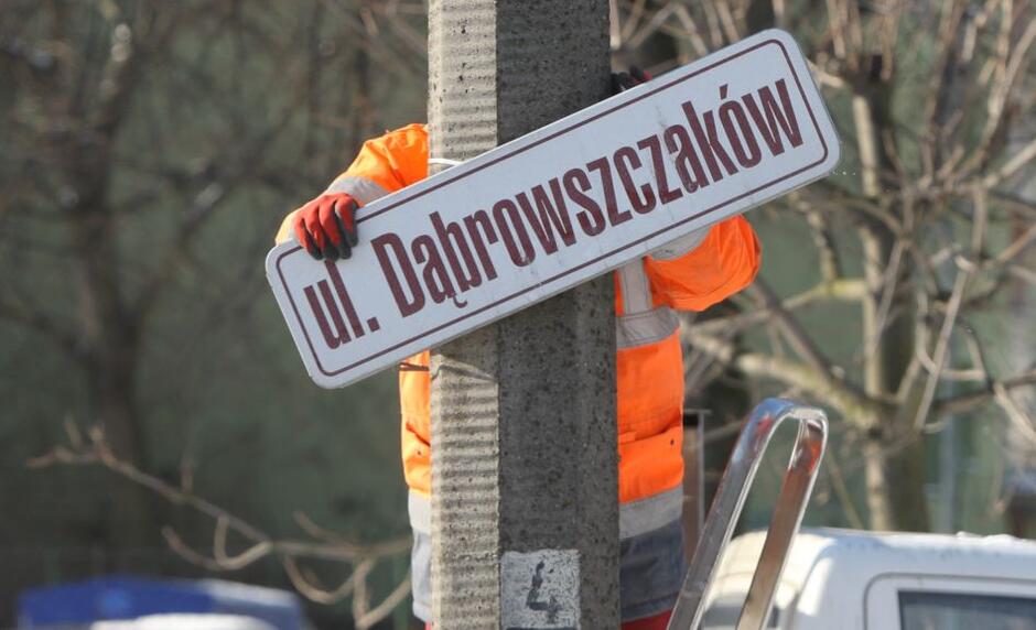 brygada remontowa demontuje tablicę z nazwą ulicy Dąbrowszczaków