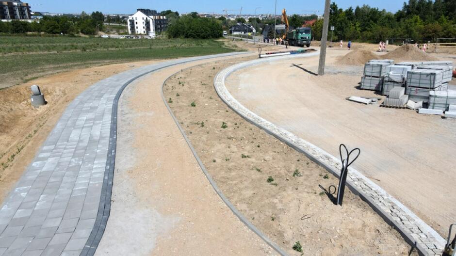 na zdjęciu plac budowy, widać fragment nowego chodnika, i powstającą drogę 