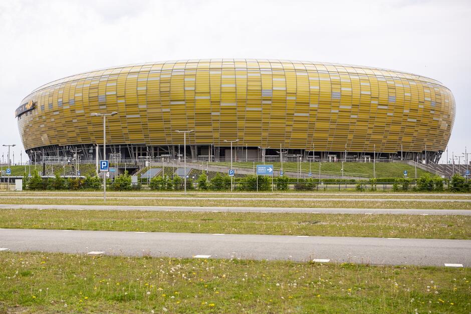 Stadion z zewnątrz w kształcie bryły bursztynu w kolorze żółtawym 