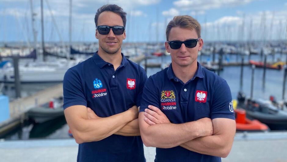 Dwóch mężczyzn z założonymi na klatce piersiowej rękoma