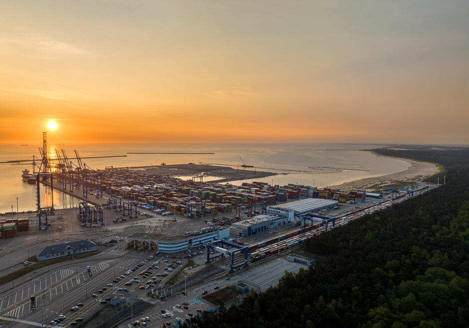 Panorama z drona, wykonana o zachodzie słońca, przedstawiająca fragment portu wraz z trwającą budową nowego terminalu.