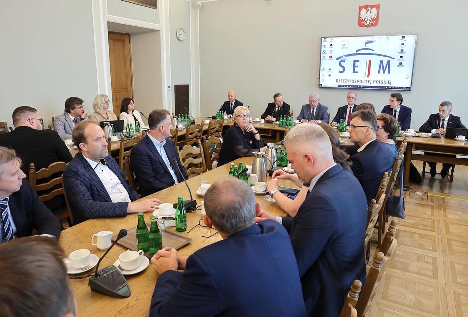 uczestnicy konferencji siedzą przy łączonych stolikach