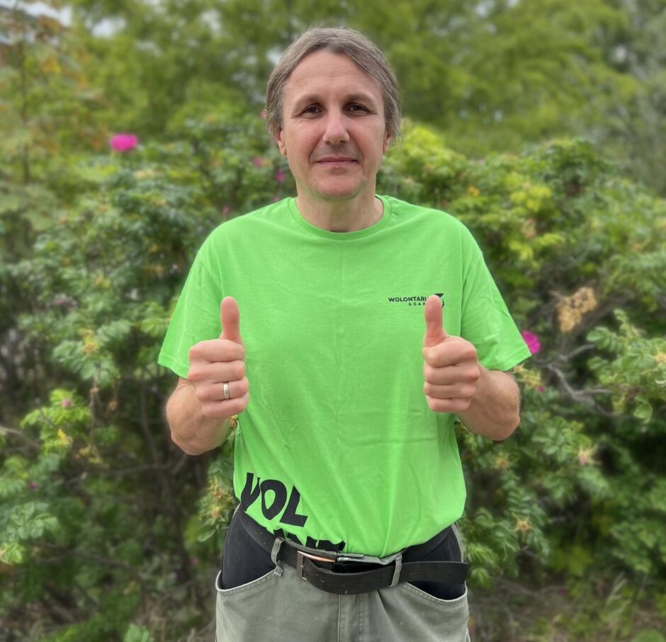 mężczyzna w średnim wieku w zielonej koszulce wolontariusza