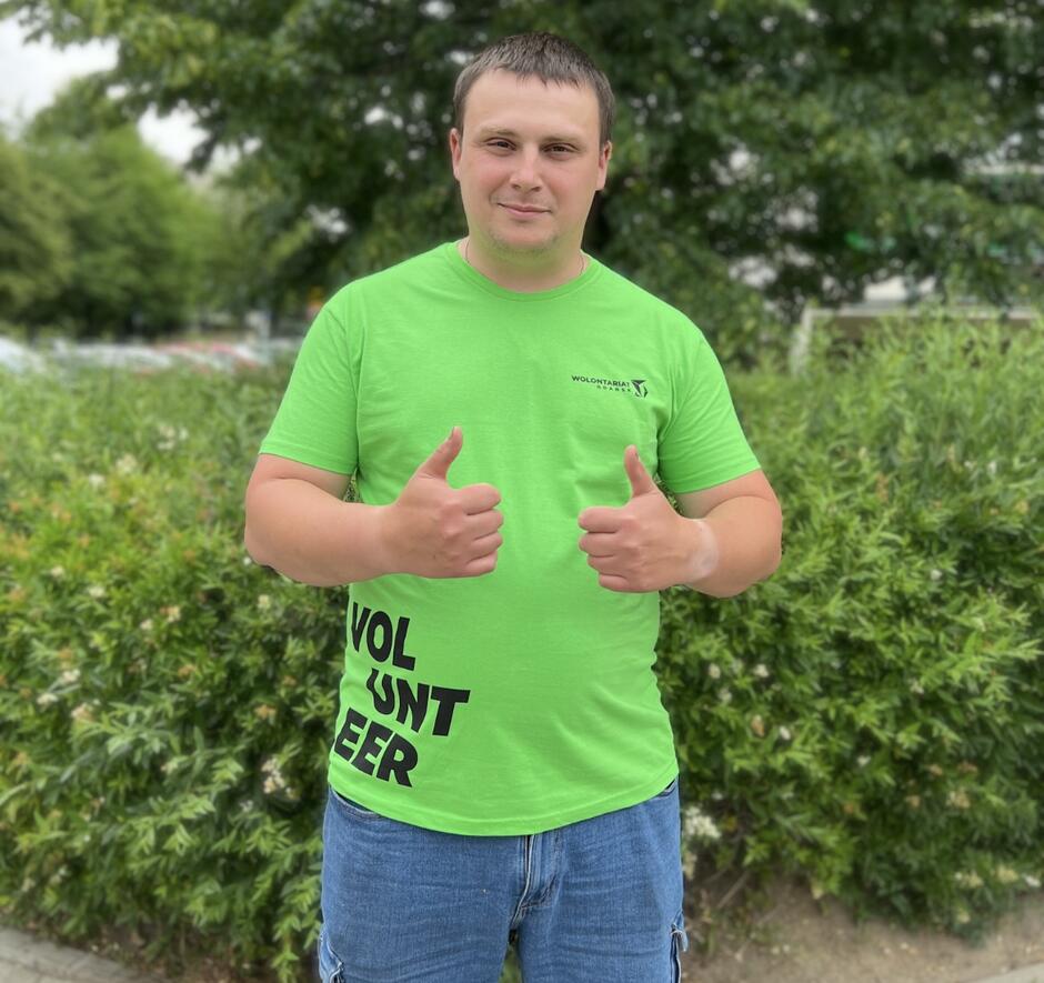 mężczyzna młody w zielonej koszulce wolontariusza