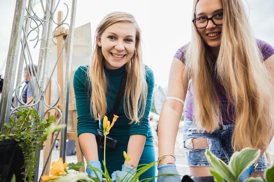 dwie młode kobiety z roślinami
