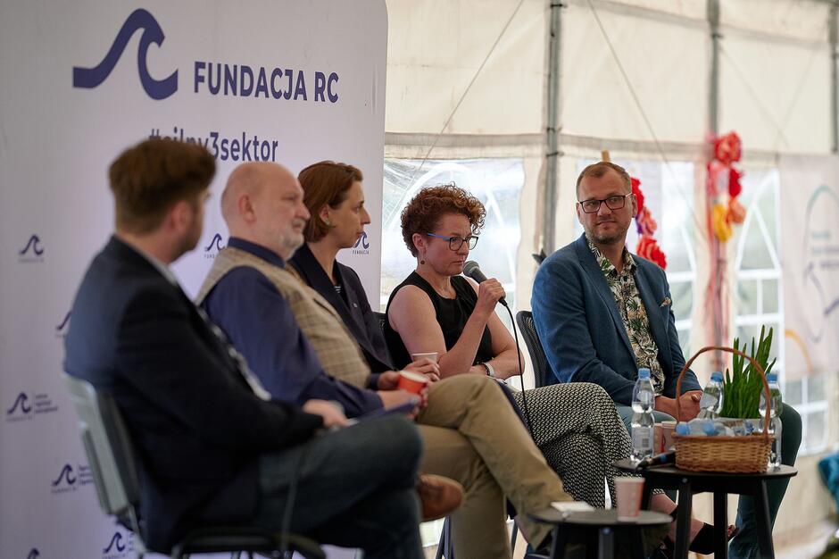 w rzędzie siedzi kilka osób