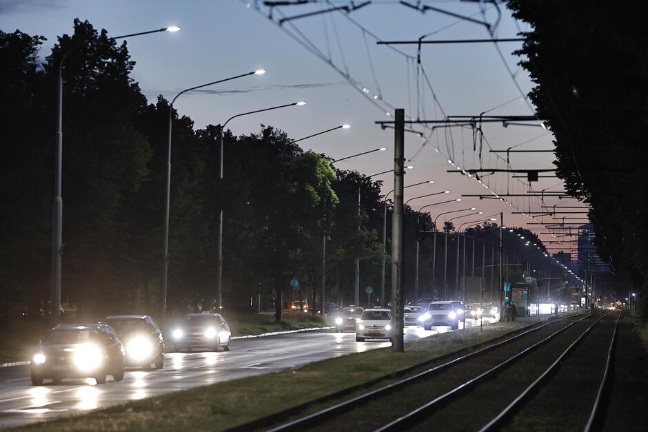 na zdjęciu jedna z głównych ulic gdańska po zmroku, widać jadące oświetlone samochody i świecące latarnie