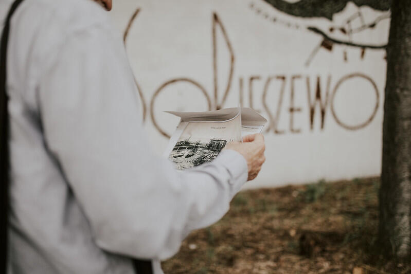 napis na ścianie Wyspa Sobieszewska  i fragment postaci ludzkiej z książką w rękach