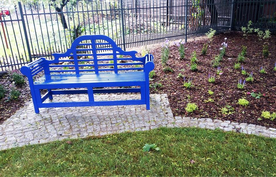 ławka stojąca na bruku, kwiaty