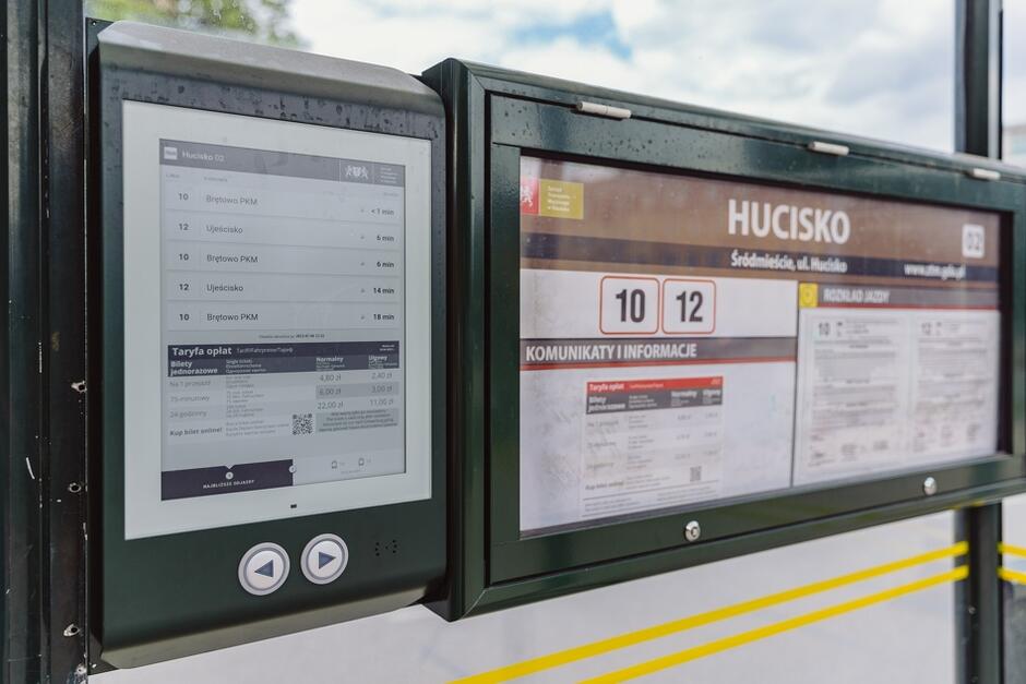 Ujęcie na rozkład jazdy na przystanku Hucisko 02, pokazujące rozkład w formie e-book i papierowej