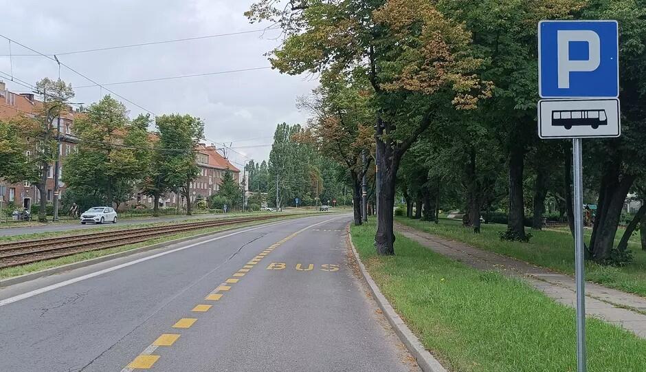 Ulica, po prawej przy krawężniku pas jezdni odznaczony żółtą linią, w środku napis: BUS