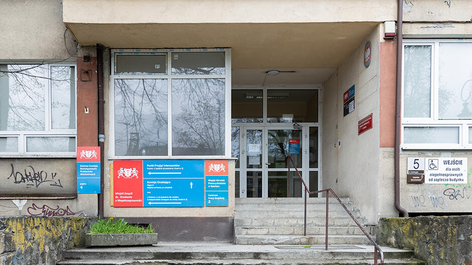 Fragment budynku: wejście, po bokach tablice informacyjne