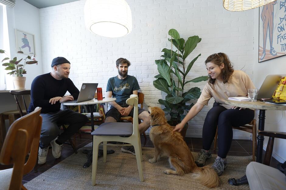wymienione osoby i pies siedzą w kawiarni