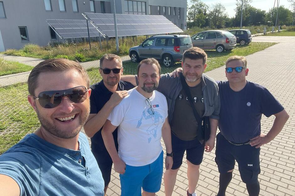 Pięciu mężczyzn z wakacyjnych strojach pozuje do wspólnego selfie