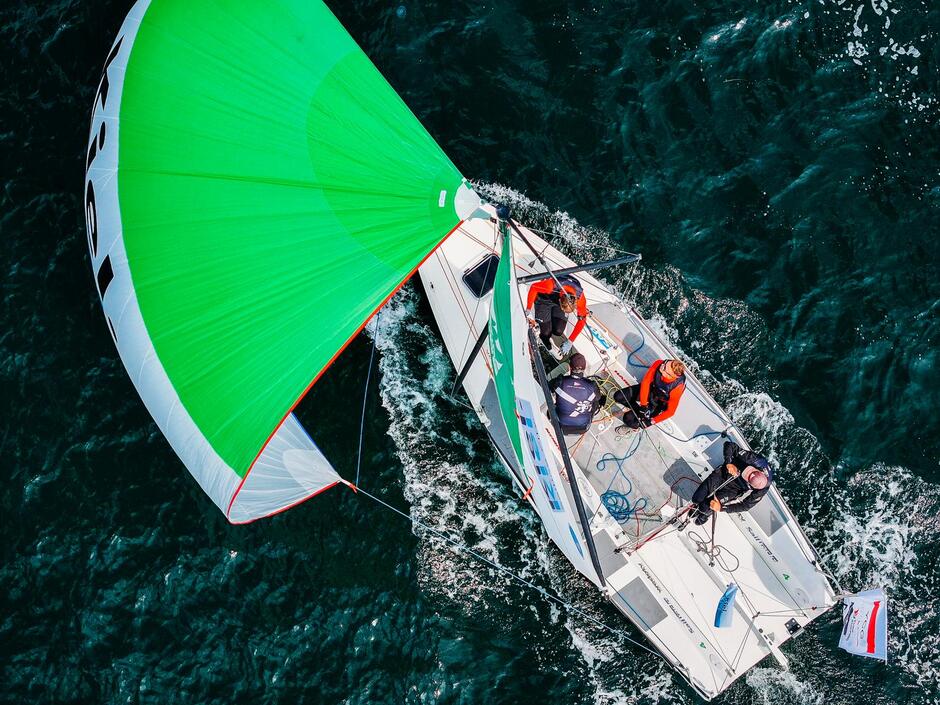 Widok z góry: łódź z zielonym żaglem na wodzie