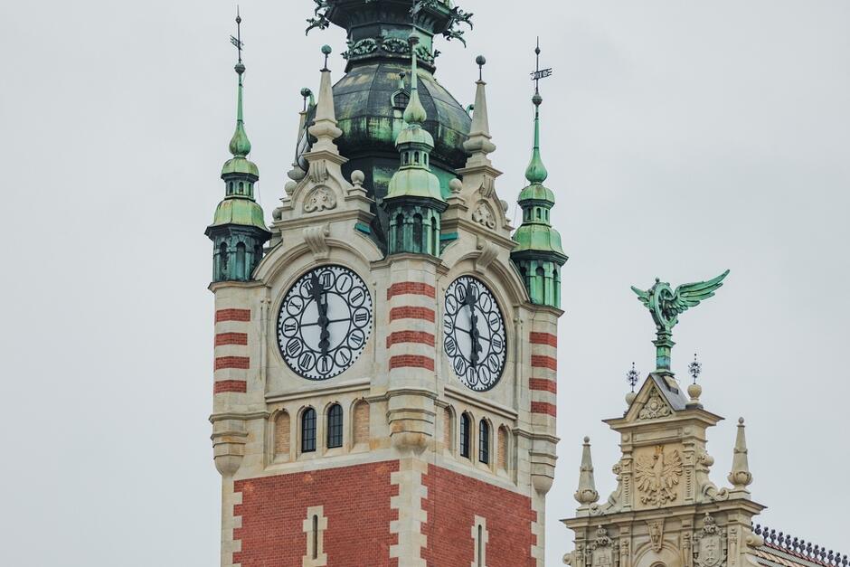 wieża z rzeźbieniami i gzymsami oraz zegarem