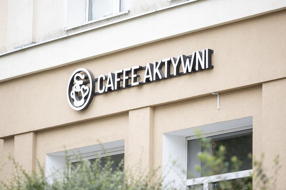 szyld z nazwą kawiarni na fasadzie budynku 