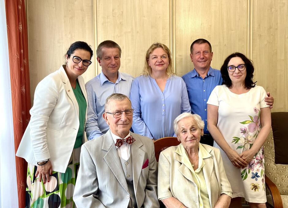 siedem osób pozuje do zdjęcia, jubilaci siedzą z przodu