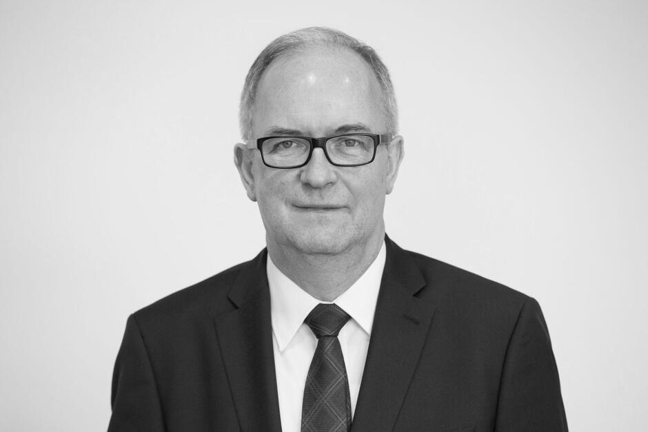 Czarno-białe zdjęcie: popiersie mężczyzny w średnim wieku 