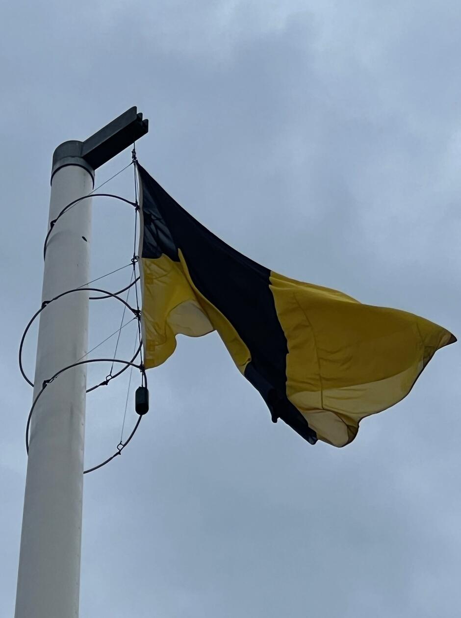 na zdjęciu czarno-złota flaga Kaszubów powiewa na maszcie