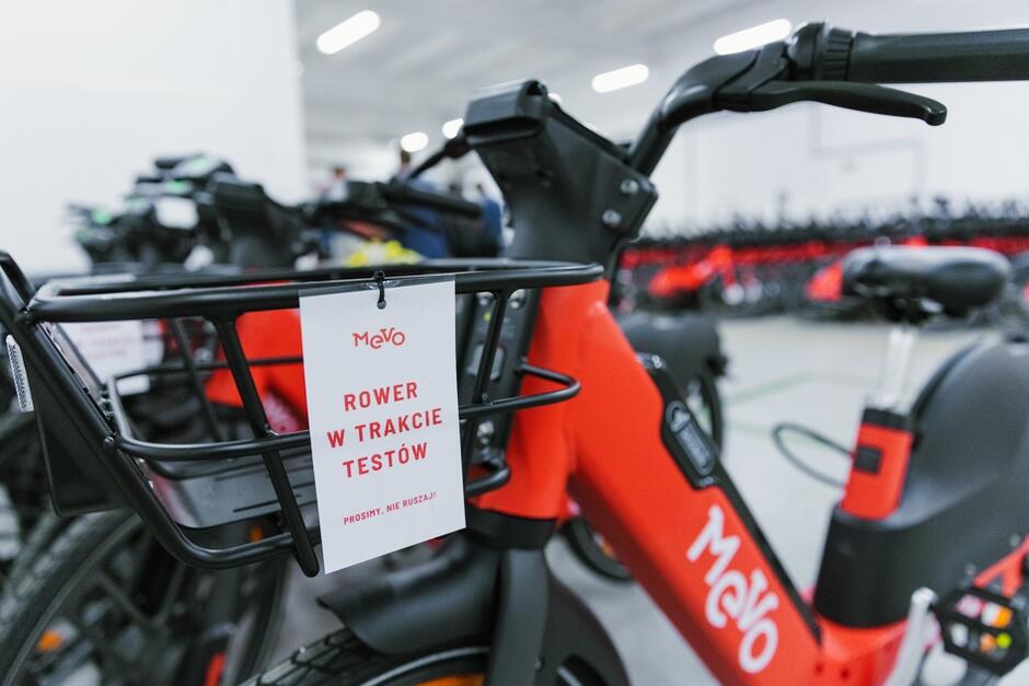 zdjęcie roweru metropolitalnego, zbliżenie na ramę, na której wisi kartka z napisem rower w trakcie testów