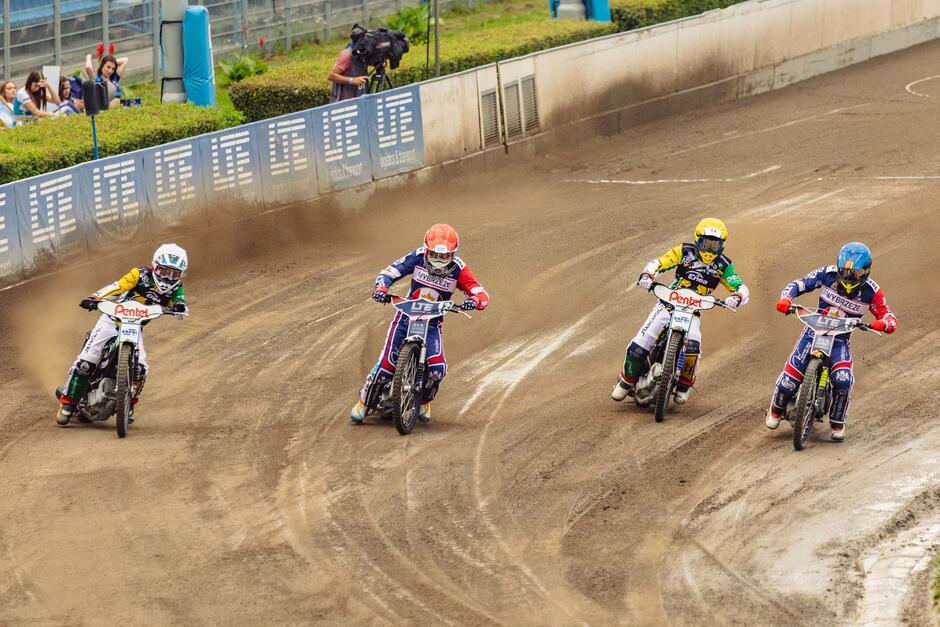 Czterech żużlowców jedzie obok siebie