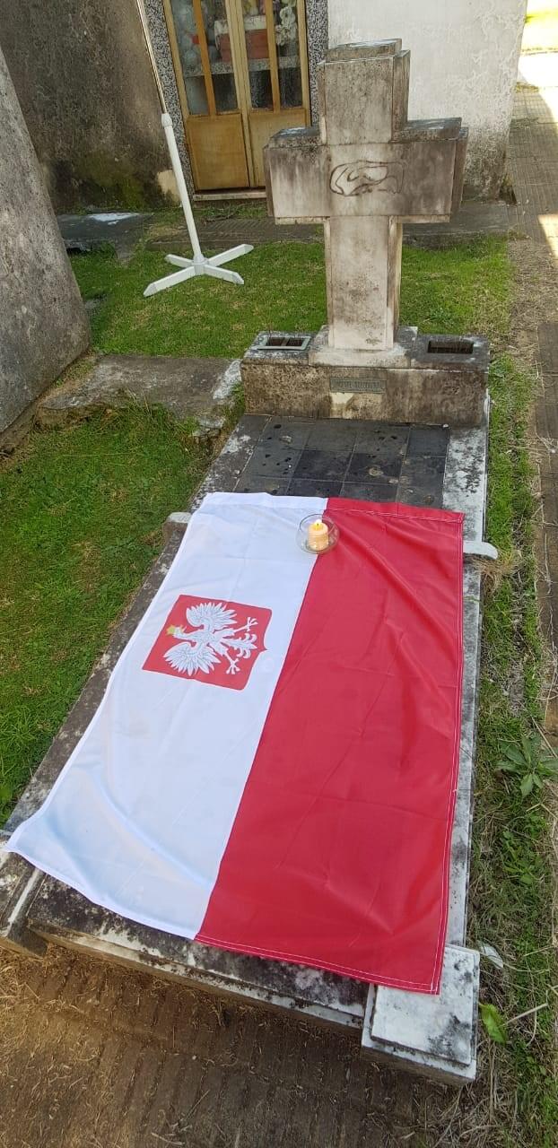 Stary grób okryty biało-czerwoną flagą