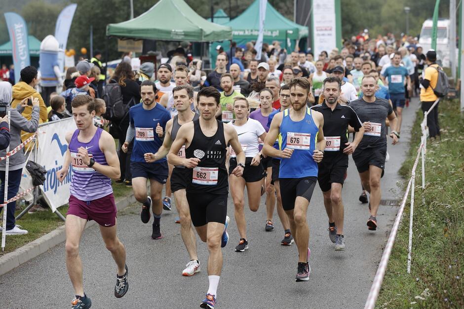 na zdjęciu kilkadziesiąt osób w średnim wieku, w strojach sportowych, biegną