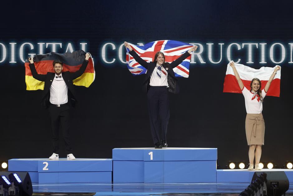 trzy osoby na medalowym podium