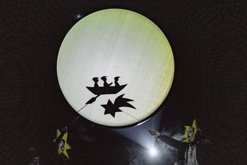 teatr cieni - na ekranie wyświetla się koło księżyca, na jego tle widać łódkę i gwiazdę. Figury trzymają aktorzy poniżej 