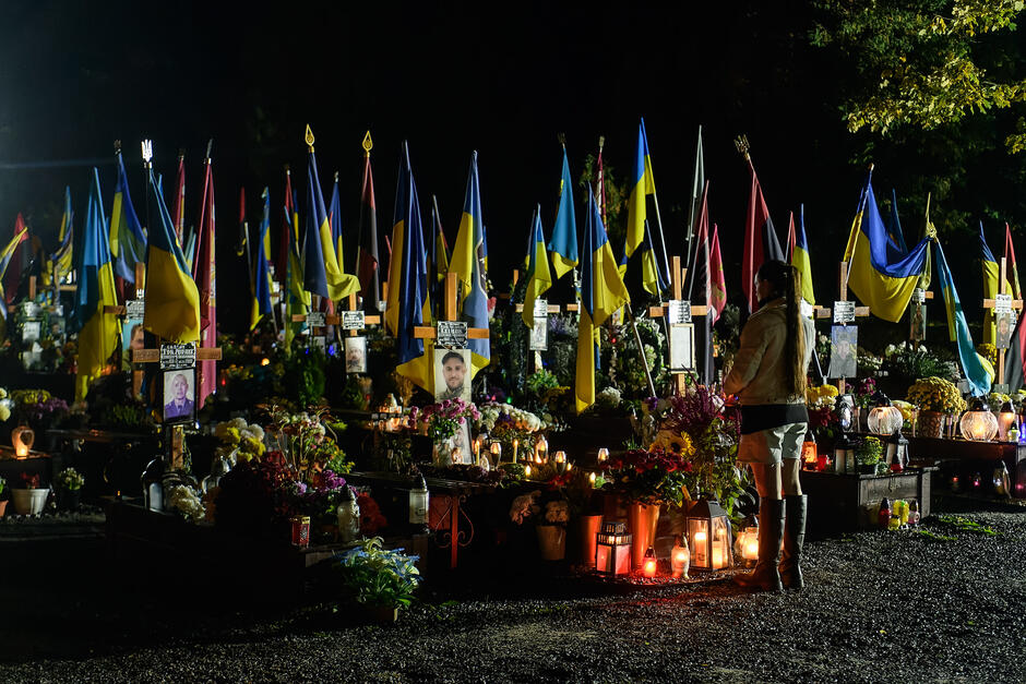 nocą cmentarz z flagami narodowymi Ukrainy