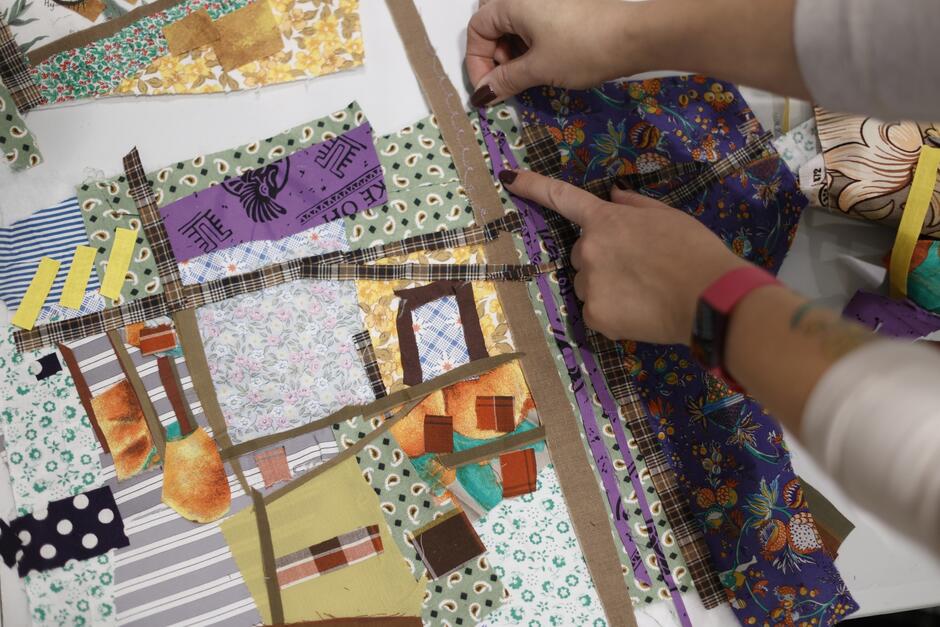 dłonie kobiety układają różne kawałki materiałów