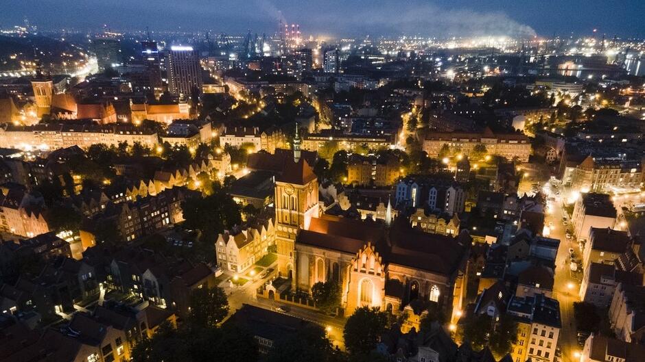 Wieczorna panorama Gdańska - widok na budynki, w centrum widać kościelną wieżę