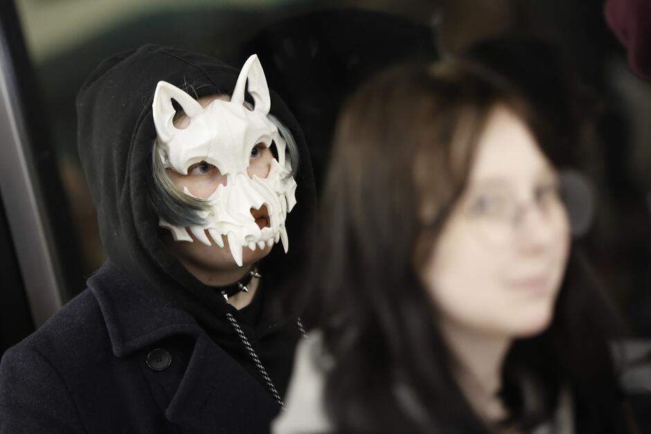 Dwie nastolatki, jedna ma na twarzy maskę zwierzęcia