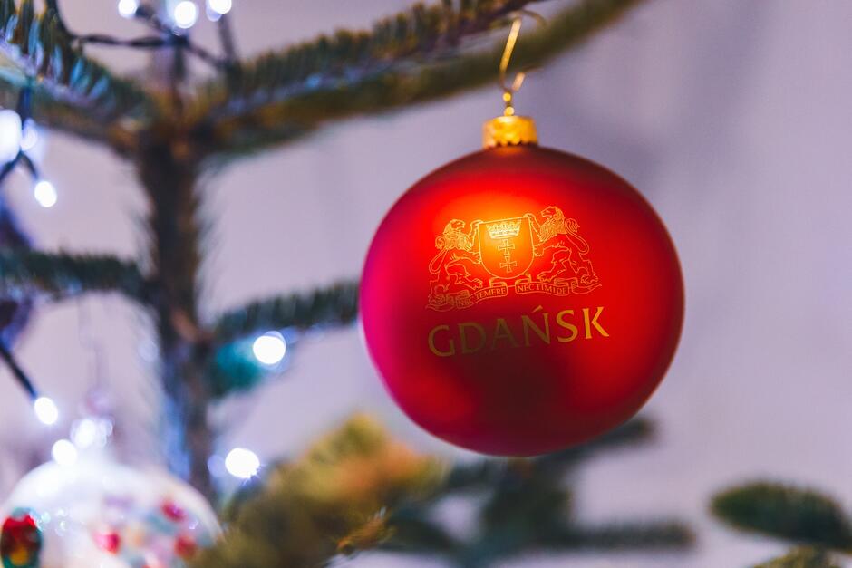zbliżenie na gałąź udekorowanej choinki i bombkę z napisem Gdańsk