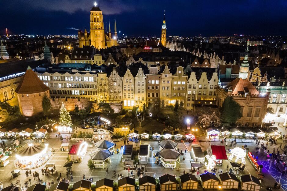 nocne zdjęcie stoisk, karuzeli, zabytków wokół